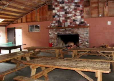 photo of the large recreation building at North of Highland campgrounds on Cape Cod, photo insert image shows the huge fireplace and picnic tables and ping pong inside the rec hall