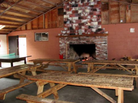photo of the large recreation building at North of Highland campgrounds on Cape Cod, photo insert image shows the huge fireplace and picnic tables and ping pong inside the rec hall