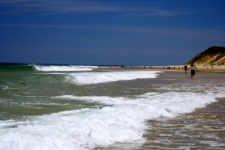 photo of waves breaking along the sandbars in North Truro, MA on Cape Cod with dunes in the background