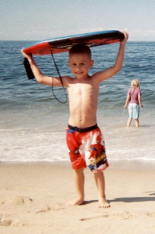 photo of a young boy carrying his boogie board from the beach near North of Highland Camping Area
