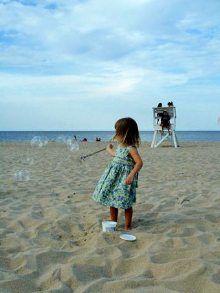 photo of a young girl blowing bubbles on the Cape Cod beach