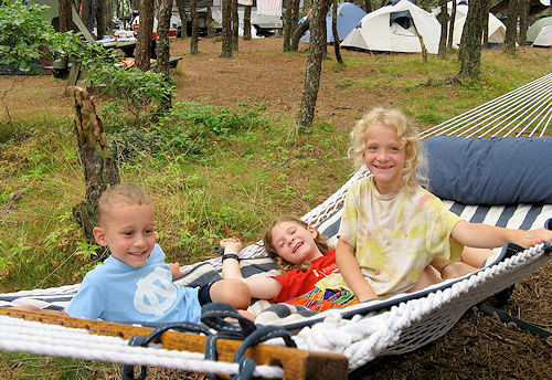 photo of three kids having fun in a hammock while camping on Cape Cod