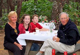 photo of family sitting arounud a campsite picnic table 