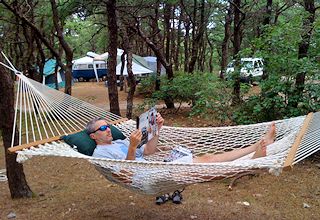 Image of a camper relaxing in his hammock while Cape Cod camping at North of Highland Camping Area